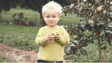 Niño en Saint-Augustin comiendo una manzana de un manzano plantado por Emondage Saint-Augustin.